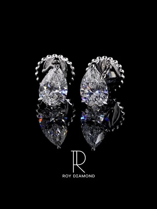 Pear-shaped diamond stud earrings on a black reflective background