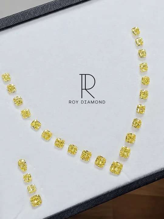 Fancy yellow cushion-cut diamonds arranged on a display tray