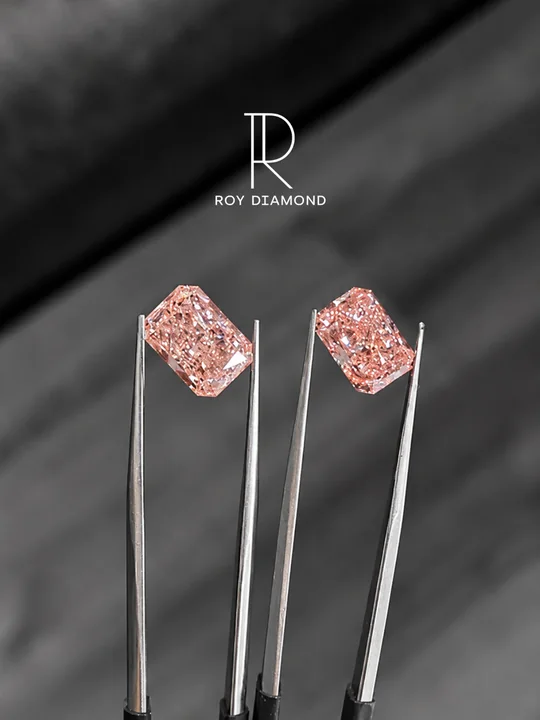 Pair of fancy pink radiant-cut diamonds held with tweezers