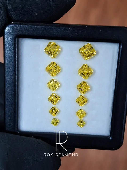 Fancy yellow Asscher-cut diamonds arranged in graduated pairs in a display box