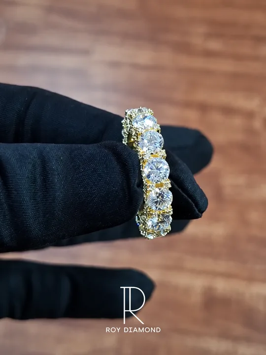 Round diamond eternity band held in a black jewellery glove